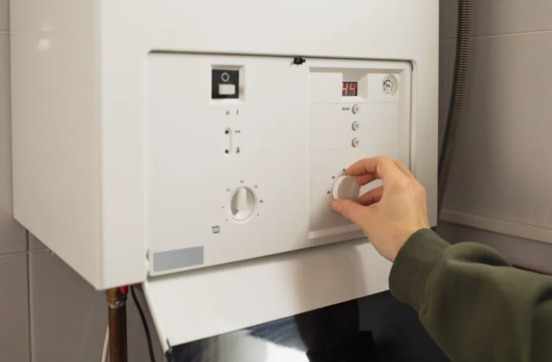 female-homeowner-is-resetting-a-gas-boiler