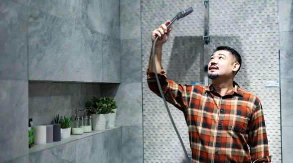 young-male-looking-at-an-electric-shower