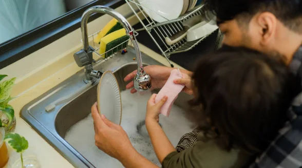 closeup-of-a-man-and-their-child-washing-dishes