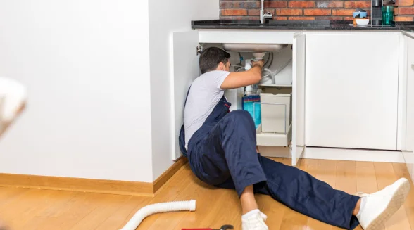 plumber-investigating-the-garbage-disposal-under-sink