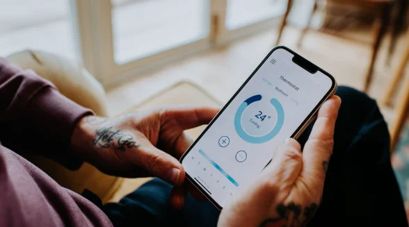 homeowner-uses-a-smartphone-to-check-the-indoor-temperature