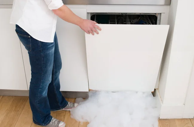 worried-woman-looking-at-her-leaky-dishwahser