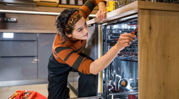 woman-repairing-a-dishwasher-leaking-from-bottom