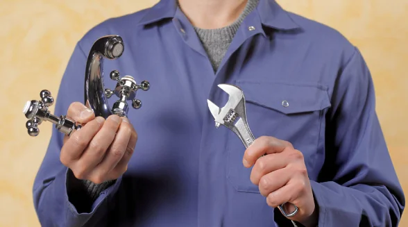 plumber-is-holding-a-mixer-tap-and-a-wrench