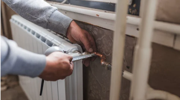 heating-engineer-is-diagnosing-a-radiator-leak