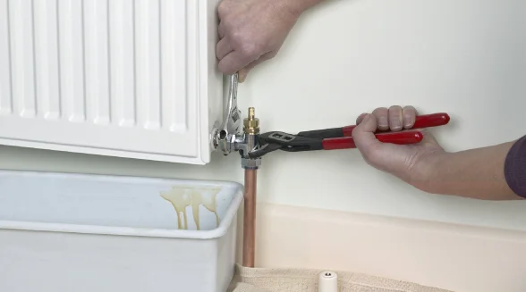 heating-engineer-is-blleding-a-radiator