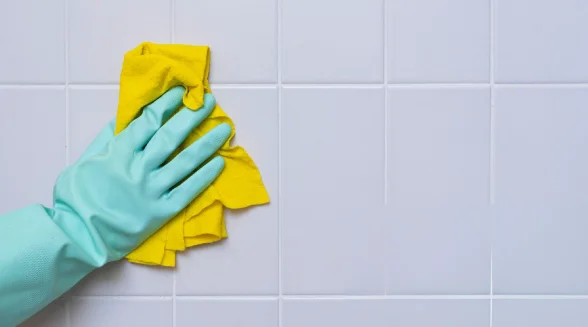 person-is-cleaning-tiles-and-removing-mouldy-silicone