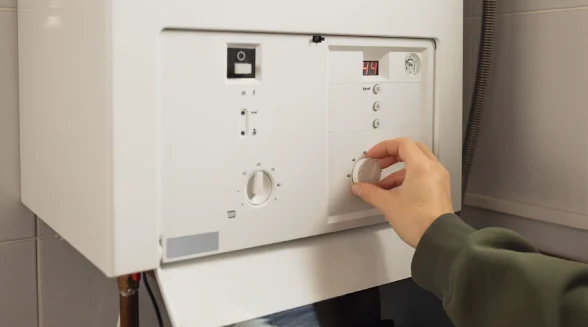 female-homeowner-is-adjusting-the-boiler-temperature
