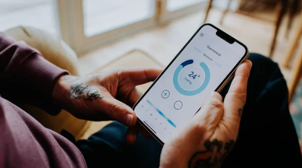 homeowner-is-controlling-his-home-thermostat-using-his-phone