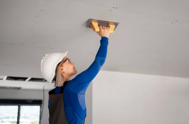 female-technician-is-trying-to-repair-a-plaster-ceiling