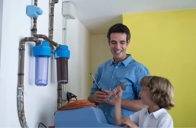 Son-helping-father-fit-water-softener