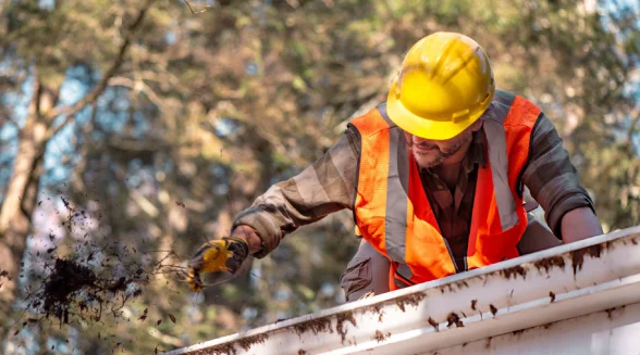tradesperson-is-cleaning-a-gutter-in-a-london-property