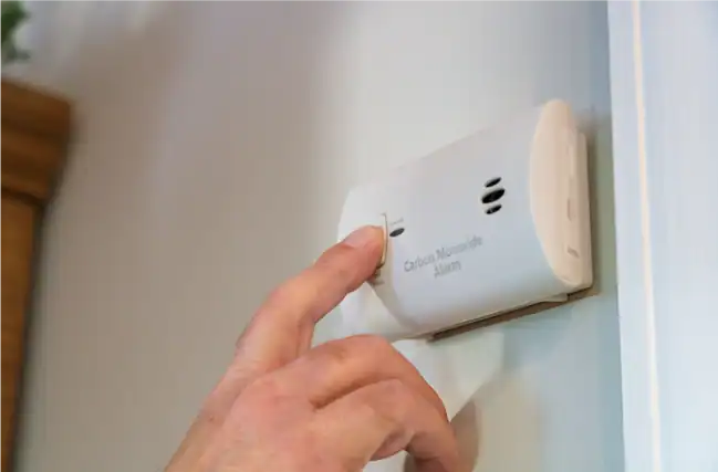 ALT - A person is turning off a false CO alarm