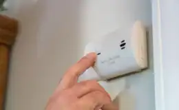 A-person-is-turning-off-a-false-CO-alarm