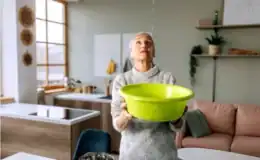 Woman-is-collecting-water-from-a-bathtub-leak-into-ceiling